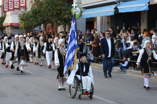 Ο μαθητής, Χρήστος Παπαθανασίου παρελαύνει περήφανος ως σημαιοφόρος του 6ου Δημοτικού Σχολείου Πατρών.