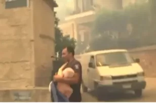 Αστυνομικός μεταφέρει ηλικιωμένο από τη φωτιά στο Γηροκομειό
