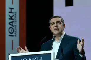 Αλέξης Τσίπρας από την Πάτρα: «Το φάντασμα της Ιθάκης πλανιέται πάνω από το καθεστώς τους» Με σαφή πολιτικά χαρακτηριστικά και ευθείες αιχμές προς την κυβέρνηση και το σύνολο του πολιτικού συστήματος, ο Αλέξης Τσίπρας επέλεξε την Πάτρα για το δεύτερο βήμα της πολιτικής επανόδου του στο προσκήνιο, μετά την ομιλία του στο θέατρο Παλλάς στην Αθήνα. Από τον κατάμεστο πολυχώρο Royal, στο κέντρο της αχαϊκής πρωτεύουσας, ο πρώην πρωθυπουργός παρουσίασε το βιβλίο του «Ιθάκη», μετατρέποντας την εκδήλωση σε μια εφ’ όλης της ύλης πολιτική παρέμβαση με έντονο αντιπαραθετικό τόνο και σαφή προοπτική μέλλοντος. Από τα πρώτα του λόγια, ο κ. Τσίπρας επεδίωξε να δώσει πολιτικό βάθος στο εγχείρημα του βιβλίου, υποστηρίζοντας ότι η «Ιθάκη» δεν αφορά μόνο το παρελθόν, αλλά «σκιαγραφεί τη ρότα του αύριο» και γι’ αυτό –όπως είπε χαρακτηριστικά– «πυροβολείται». Μιλώντας για «αποκατάσταση της ιστορικής αλήθειας», έκανε λόγο για μια αναγκαία προϋπόθεση ώστε η κοινωνία να κατανοήσει το σήμερα και να σχεδιάσει το αύριο, υπογραμμίζοντας ότι «το διάβασμα ενός βιβλίου στην εποχή των συνθημάτων αποτελεί πράξη αντίστασης». Ιδιαίτερη αίσθηση προκάλεσε η φράση του ότι «το φάντασμα της Ιθάκης πλανιέται πάνω από το καθεστώς τους», δίνοντας τον τόνο μιας ομιλίας που επανειλημμένα επανέφερε τη μεταφορά του «βάλτου» για να περιγράψει τη σημερινή κατάσταση της χώρας. «Μας αξίζει αυτός ο βάλτος; Υπάρχει αύριο;» διερωτήθηκε, απευθυνόμενος σε ένα ακροατήριο που τον χειροκροτούσε θερμά. Ο πρώην πρωθυπουργός εξαπέλυσε σφοδρή επίθεση στην κυβέρνηση, κάνοντας λόγο για «λάθος κυβέρνηση» που εφαρμόζει «καταστροφικά δόγματα άγριου νεοφιλελευθερισμού, βαλκανικού τύπου». Αναφέρθηκε εκτενώς σε σκάνδαλα και υποθέσεις διαφθοράς, μιλώντας για «βάλτο υποκλοπών, Τεμπών, ΟΠΕΚΕΠΕ και καρτέλ», ενώ δεν δίστασε να χρησιμοποιήσει αιχμηρές εκφράσεις για «φραπέδες και χασάπηδες» που –όπως είπε– λυμαίνονται το δημόσιο χρήμα, προειδοποιώντας ότι όσα έχουν δει το φως της δημοσιότητας είναι «μόνο η κορυφή του παγόβουνου». Ξεχωριστή ενότητα της ομιλίας αφιερώθηκε στον πρωτογενή τομέα και στις αγροτικές κινητοποιήσεις. Ο κ. Τσίπρας μίλησε για «μπλόκα της οργής» και απέδωσε την κρίση σε συνειδητές κυβερνητικές επιλογές που, όπως υποστήριξε, άφησαν τους αγρότες «αβοήθητους», ενώ τα κονδύλια του Ταμείου Ανάκαμψης κατευθύνθηκαν σε λίγες μεγάλες επιχειρήσεις. Παρουσίασε συγκεκριμένες προτάσεις άμεσης στήριξης, καλώντας την κυβέρνηση να δώσει «τώρα» λύσεις, προειδοποιώντας ότι «η παραγωγή δεν μπορεί να περιμένει». Στο πεδίο της οικονομίας, ο πρώην πρωθυπουργός αντιπαρέβαλε τα στοιχεία της διακυβέρνησης 2015-2019 με τα σημερινά δεδομένα, υποστηρίζοντας ότι η χώρα παραδόθηκε το 2019 «εκτός μνημονίων, με μαξιλάρι 40 δισ. και σε τροχιά ανάπτυξης». «Η αλήθεια είναι πεισματάρα», είπε, καλώντας σε σύγκριση μισθών, τιμών ρεύματος και αγοραστικής δύναμης, ενώ προκάλεσε την κυβέρνηση να απευθυνθεί στην κοινωνία με «αντικειμενικά ερωτήματα» για την αποτελεσματικότητα και την εντιμότητά της. Παράλληλα, δεν άφησε εκτός κριτικής την αντιπολίτευση, μιλώντας για έλλειψη πειστικής εναλλακτικής πρότασης και για έναν κατακερματισμό που –όπως είπε– διευκολύνει τη Δεξιά να αναζητά «ασφαλή προσγείωση». Σε αυτό το πλαίσιο, έθεσε ανοιχτά την ανάγκη για μια «ισχυρή προοδευτική παράταξη» μέσα από διαδικασίες «από τα κάτω», με πρωτοβουλίες αυτοοργάνωσης και ενεργό ρόλο των πολιτών. Κλείνοντας, ο Αλέξης Τσίπρας μίλησε για «σοκ εμπιστοσύνης» και «σεισμική αλλαγή πολιτικών συσχετισμών», καλώντας σε έναν «νέο πατριωτισμό» εντιμότητας και δικαιοσύνης. «Ο κοιμισμένος γίγαντας είναι η κοινωνία», τόνισε, δηλώνοντας ότι συνεχίζει να αγωνίζεται γιατί «ο νόστος της αλλαγής είναι πιο ισχυρός από τις φουρτούνες». Από την Πάτρα, το μήνυμα ήταν σαφές: η «Ιθάκη» παρουσιάστηκε όχι μόνο ως βιβλίο, αλλά ως πολιτικό κάλεσμα για το επόμενο ταξίδι.