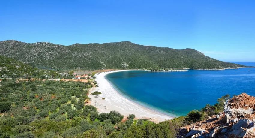 Παραλία Φωκιανός στην Αρκαδία με λευκά βότσαλα, κυανοπράσινα νερά και καταπράσινες πλαγιές του Πάρνωνα