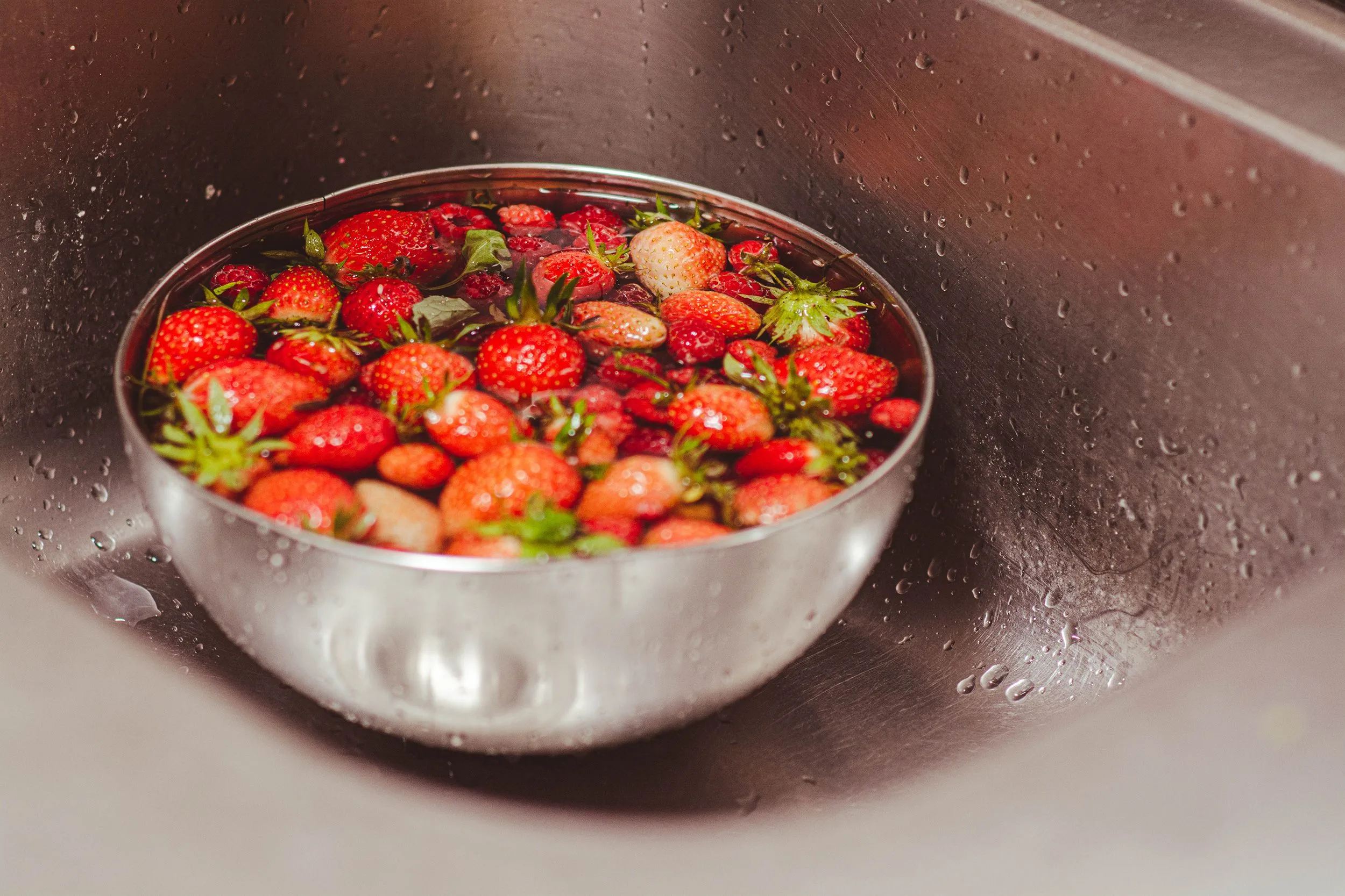 Φράουλες και μούρα: Πώς να τα πλένετε σωστά για λιγότερα φυτοφάρμακα Φράουλες σε μπολ με νερό για σωστό πλύσιμο και μείωση φυτοφαρμάκων