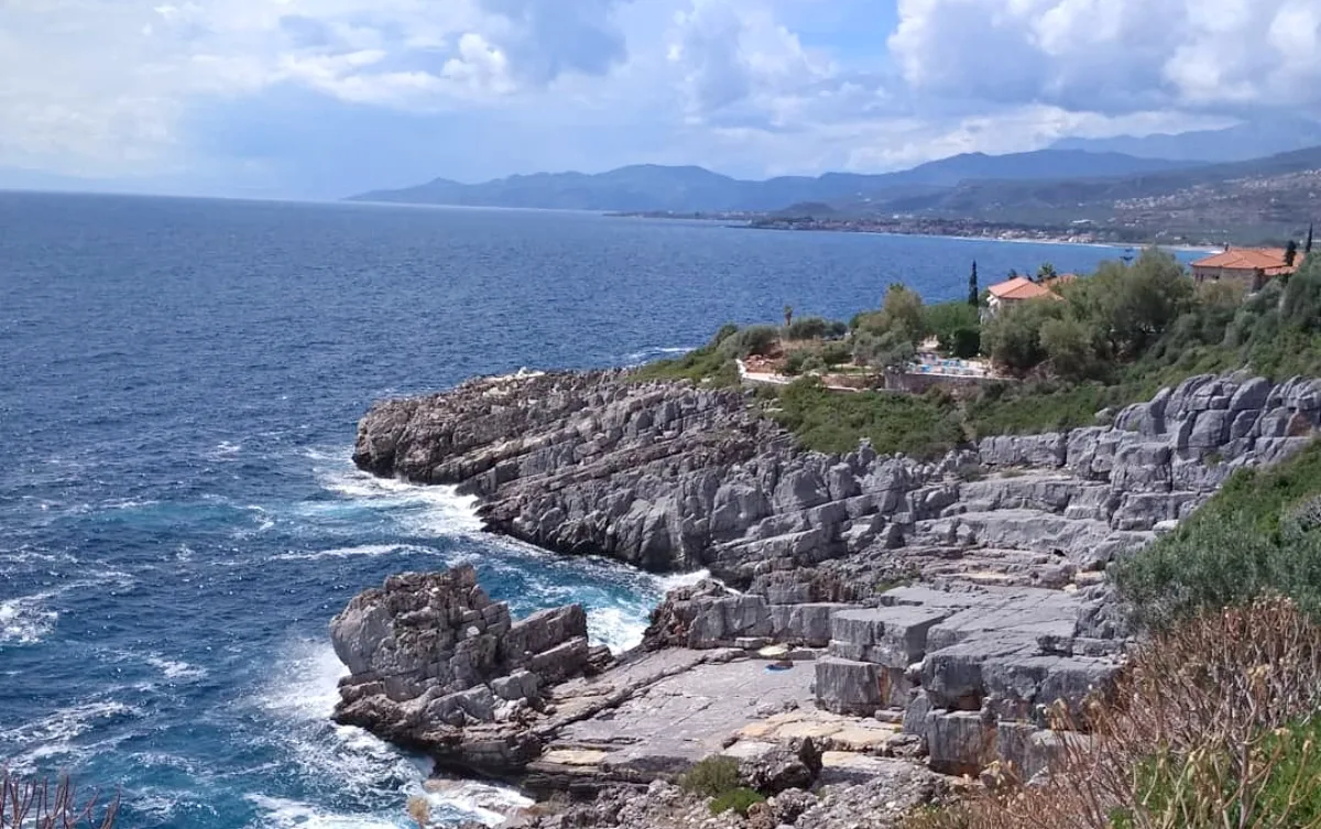 Παραλία Καταφύγι στη Μεσσηνιακή Μάνη με πέτρινες πλάκες, καθαρά νερά και βραχώδες τοπίο