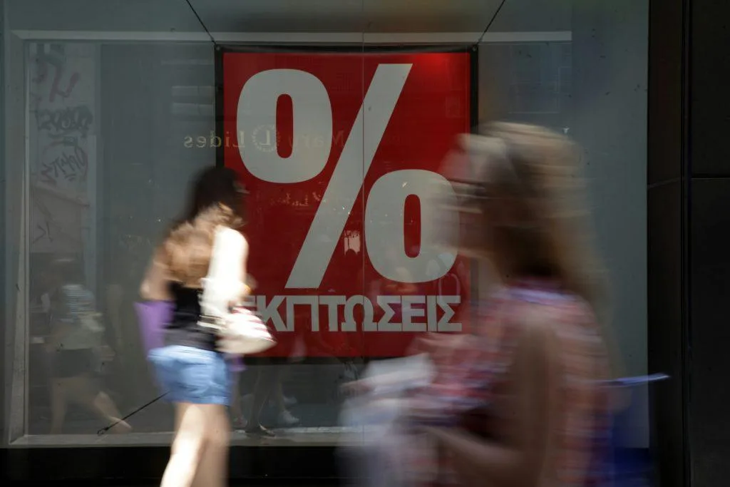Βιτρίνες καταστημάτων με ανακοινώσεις για τις θερινές εκπτώσεις 2026