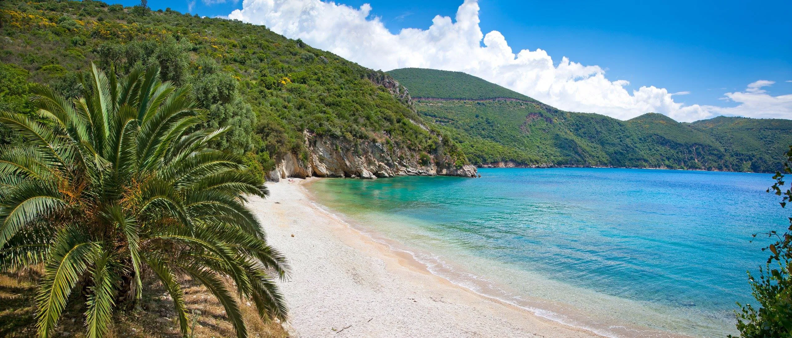 Πάργα: Παραλίες, κάστρο, Παξοί και Αντίπαξοι σε μία απόδραση που τα έχει όλα Παραλία Αϊ Γιαννάκης στην Πάργα με γαλαζοπράσινα νερά, ήρεμη ακτή, φοίνικες και καταπράσινους λόφους γύρω από τον κόλπο