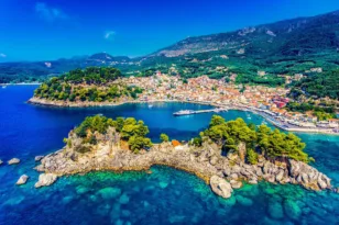 Πανοραμική άποψη της Πάργας με τιρκουάζ νερά, μικρά καταπράσινα νησάκια, παραθαλάσσιο οικισμό και φόντο τους λόφους της Ηπείρου.