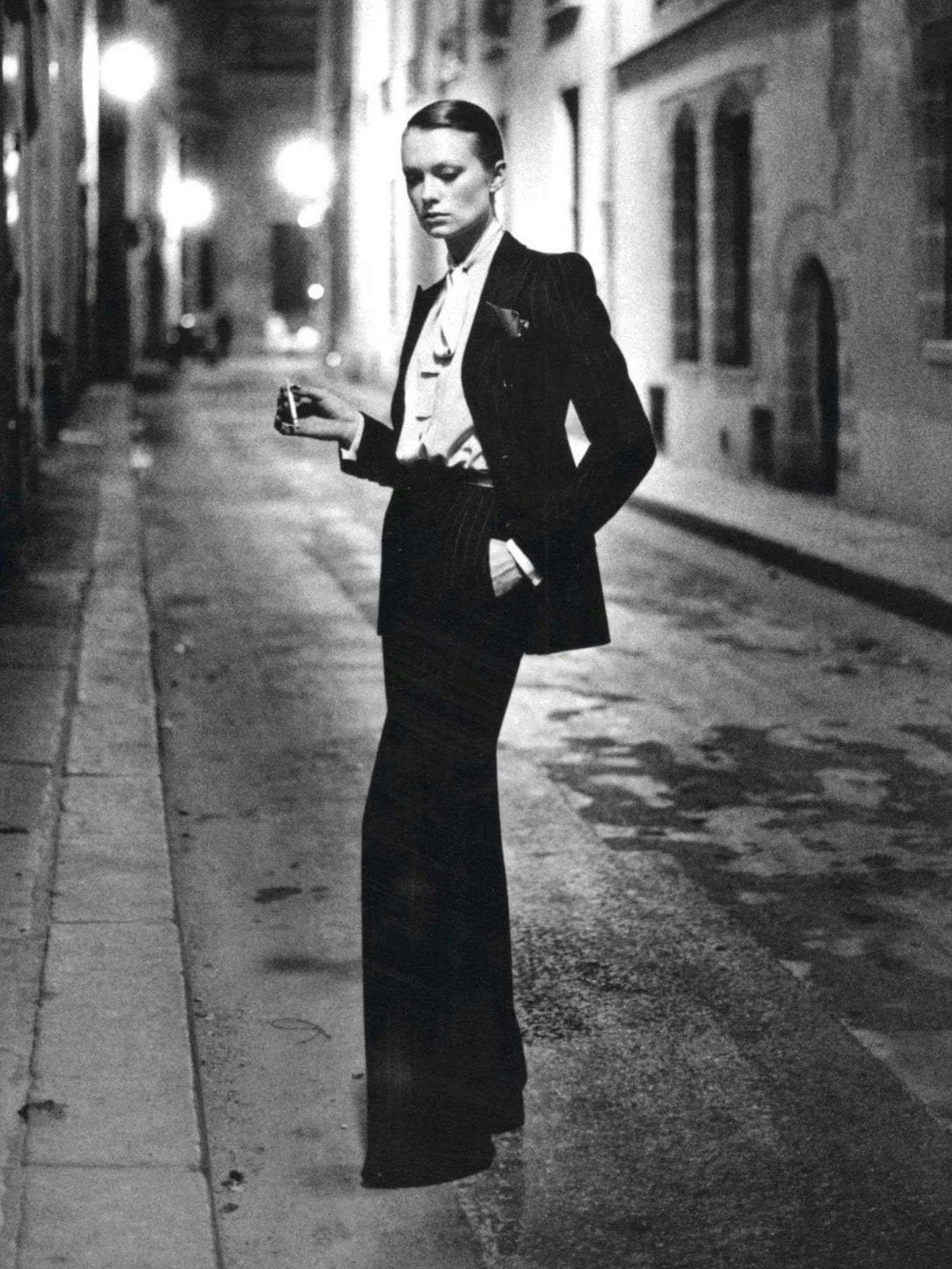Yves Saint Laurent: Το βράδυ που ένα παντελόνι έγινε πιο προκλητικό από γυμνά πόδια Το 1975, ο Helmut Newton φωτογράφισε μια γυναίκα με Le Smoking στη Rue Aubriot του Παρισιού
