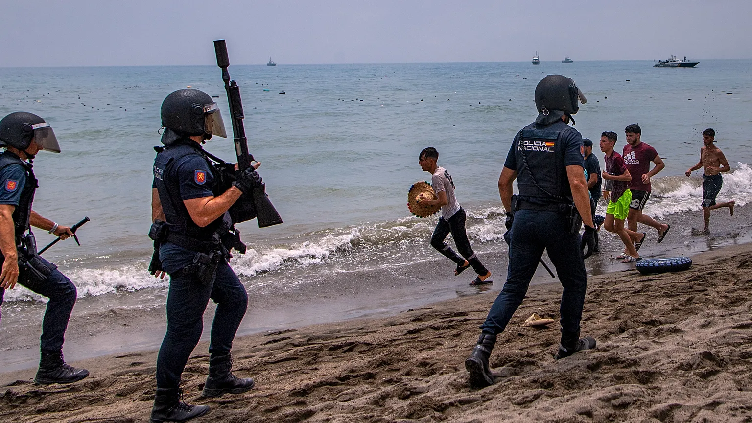 Η Ισπανία υψώνει πλωτό «τείχος» στη Θέουτα – 48.000 άνθρωποι επέστρεψαν στο Μαρόκο Ισπανοί αστυνομικοί κινούνται σε παραλία της Θέουτα, ενώ άνδρες βγαίνουν τρέχοντας από τη θάλασσα