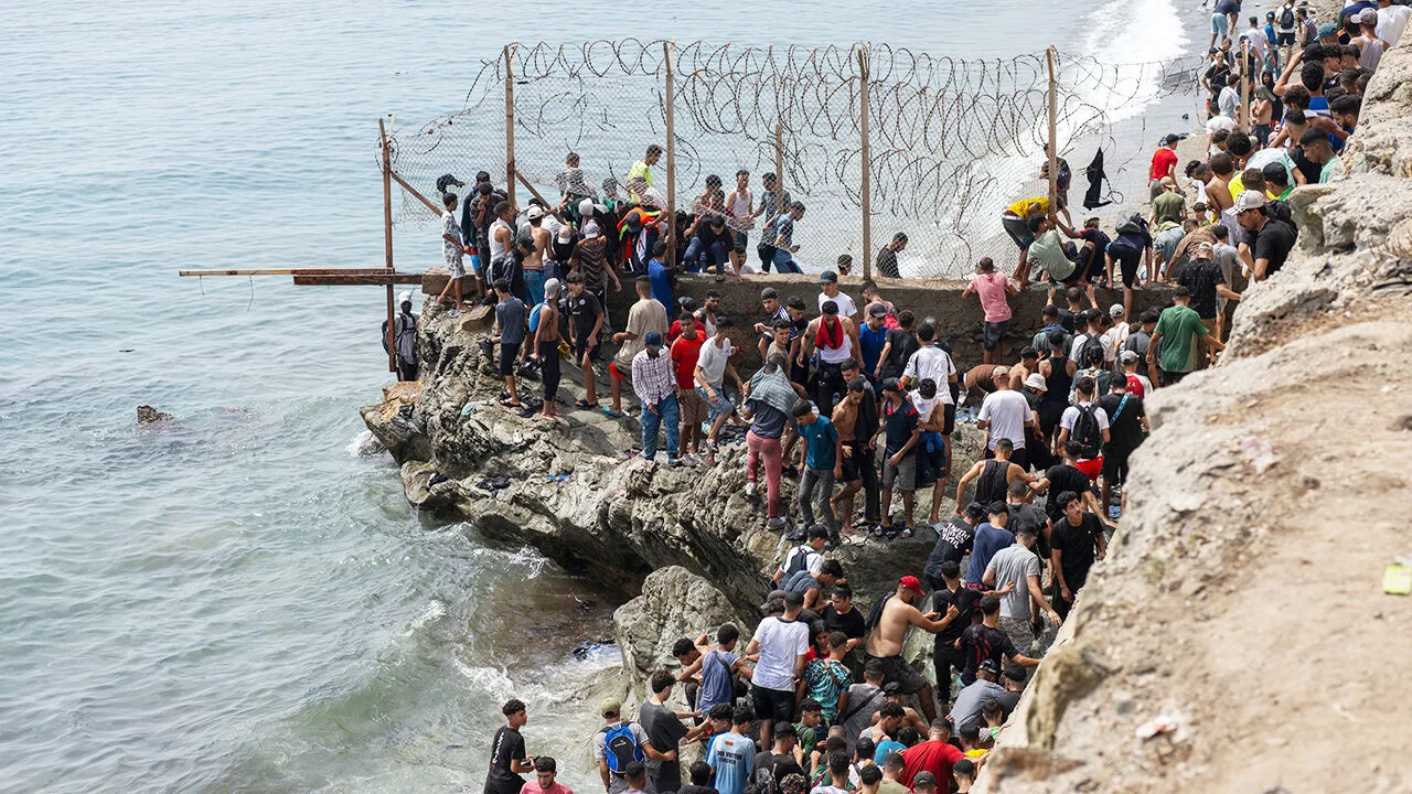 Η Ισπανία υψώνει πλωτό «τείχος» στη Θέουτα – 48.000 άνθρωποι επέστρεψαν στο Μαρόκο Πλήθος ανθρώπων συγκεντρωμένο σε βραχώδη ακτή δίπλα στον συνοριακό φράχτη με τα συρματοπλέγματα στη Θέουτα