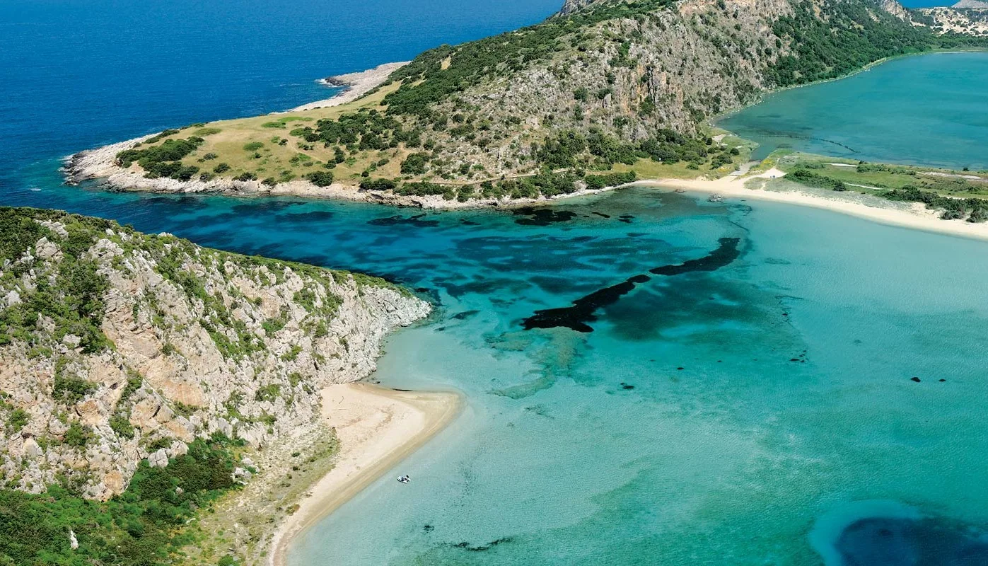 Το καλοκαίρι έχει σχήμα Ω – Ο ολοκληρωμένος καλοκαιρινός οδηγός για τη δυτική Μεσσηνία Το Πέρασμα της Συκιάς κοντά στην Πύλο, με τιρκουάζ νερά, αμμώδεις ακτές και βραχώδεις σχηματισμούς