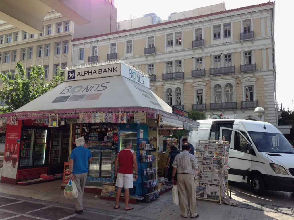 Το ψυγείο του περιπτέρου: Δραχμές, δωράκια και παγωτά που δεν ξεχάσαμε Παραδοσιακό ελληνικό περίπτερο με εφημερίδες και προϊόντα.