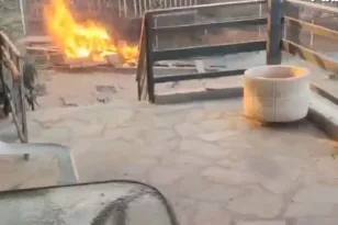 Αστυνομικοί απομακρύνουν ηλικιωμένη από το σπίτι της ενώ οι φλόγες έχουν φτάσει στην αυλή στον Κουβαρά