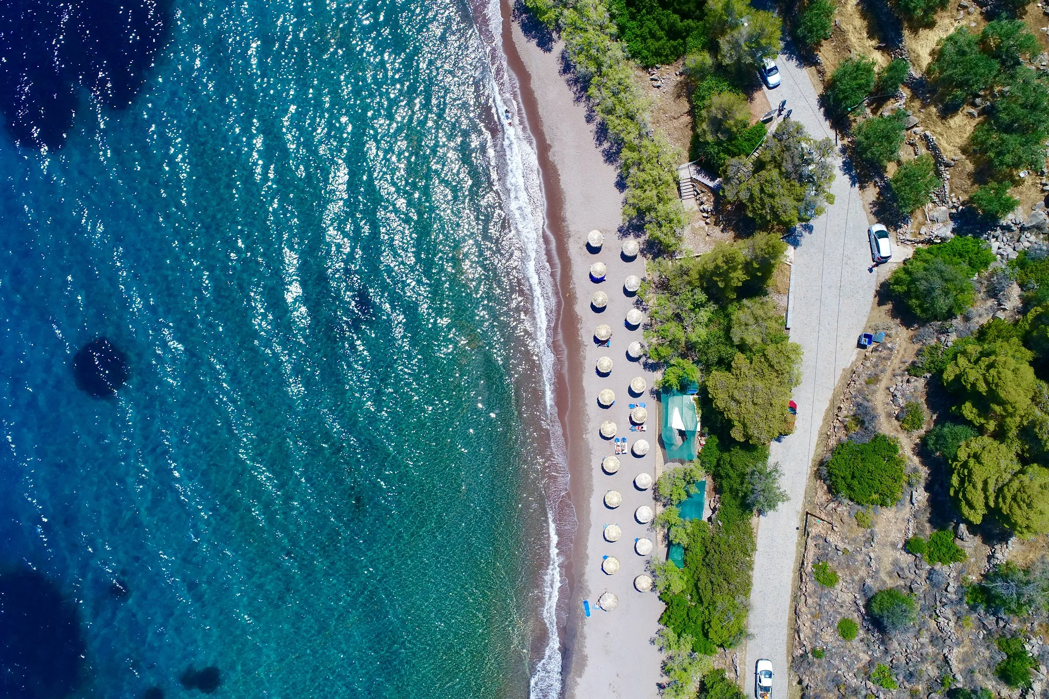 Το «νησί» της Πελοποννήσου που πας χωρίς πλοίο – Ηφαίστειο, θερμές πηγές και μικρά λιμάνια Η παραλία Λιμνιώνας στα Μέθανα με πρασινογάλαζα νερά και πυκνή βλάστηση.