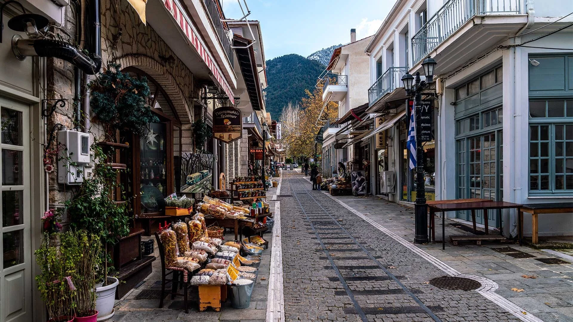 Αυτός είναι ο λόγος που τα Καλάβρυτα δεν είναι μόνο χειμερινός προορισμός Πεζόδρομος στο κέντρο των Καλαβρύτων με καταστήματα και το βουνό στο βάθος