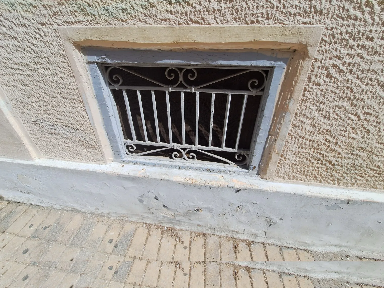 Οι πόρτες και τα κάγκελα της Πάτρας: Τα σχέδια που επιμένουν στις προσόψεις Χαμηλό παράθυρο με απλό σιδερένιο κάγκελο