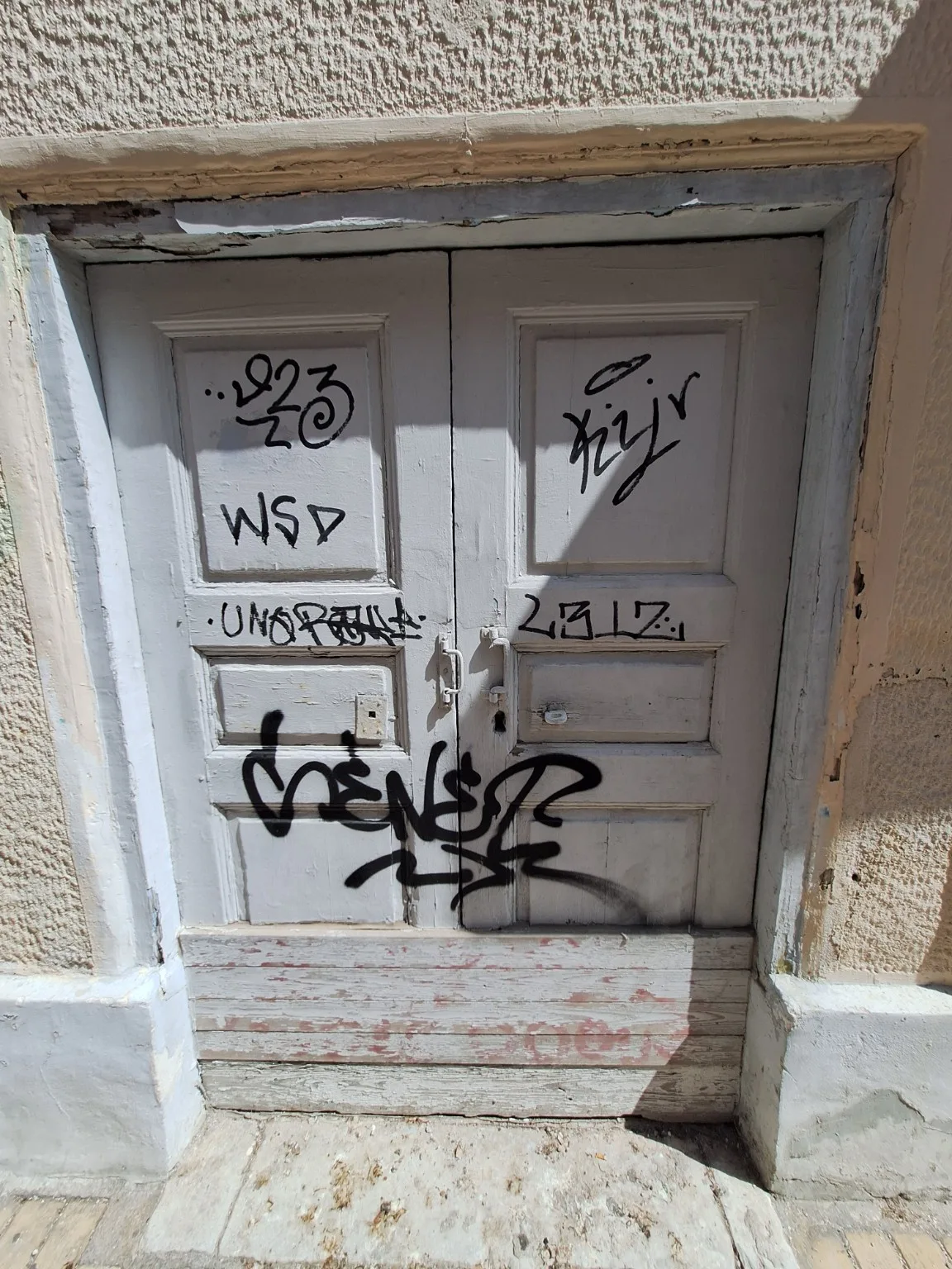 Οι πόρτες και τα κάγκελα της Πάτρας: Τα σχέδια που επιμένουν στις προσόψεις patra.jpgΦθαρμένη ξύλινη πόρτα με γκράφιτι στην Πάτρα