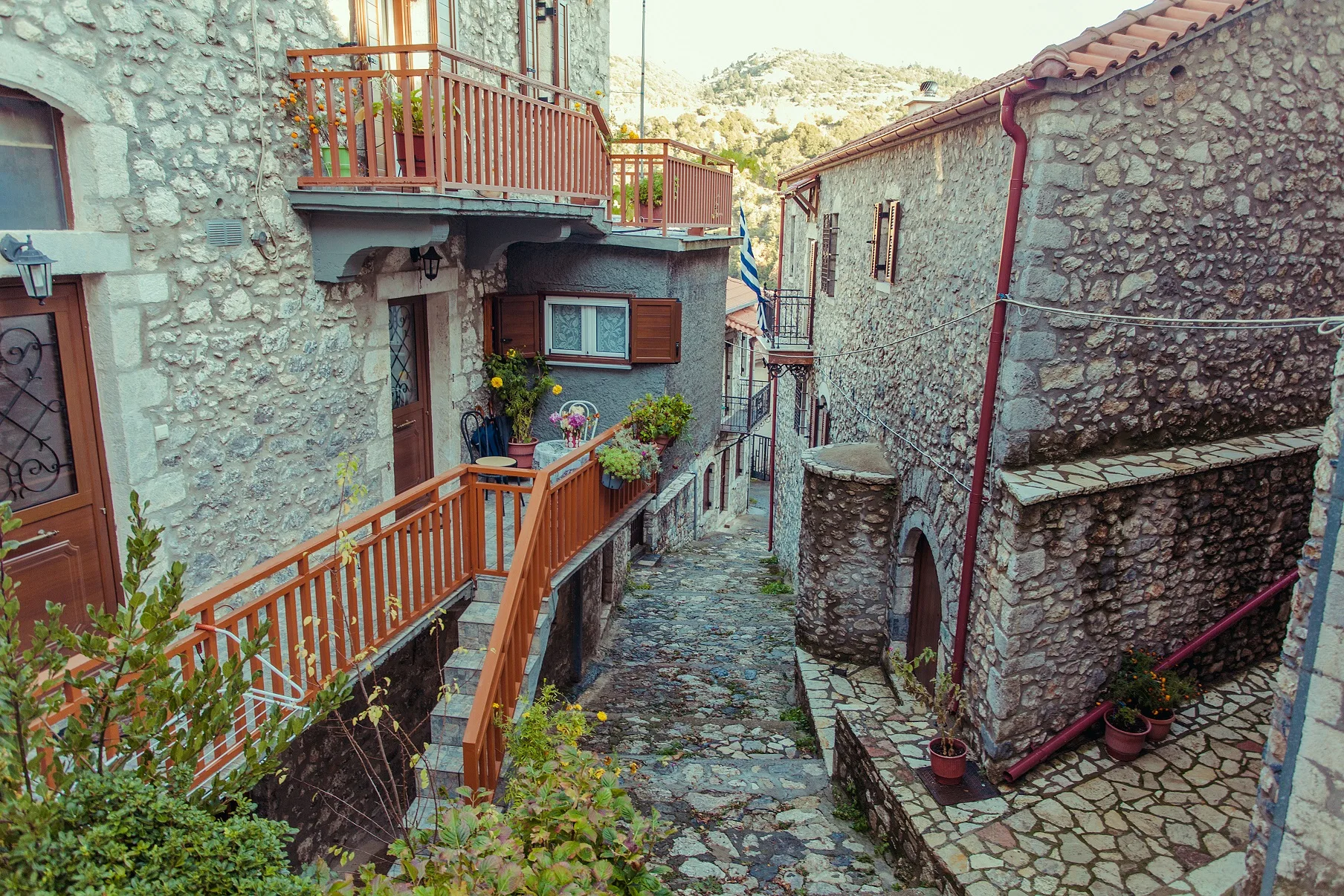 Αυτό το χωριό είναι η εικόνα που έχουμε στο μυαλό μας όταν λέμε «φθινοπωρινή απόδραση» Λιθόστρωτο σοκάκι ανάμεσα σε πέτρινα σπίτια με ξύλινα μπαλκόνια στη Στεμνίτσα Αρκαδίας