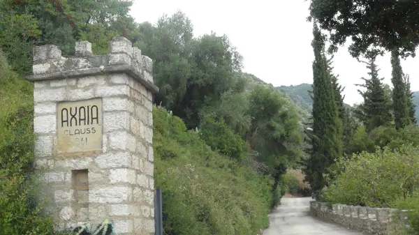 Πριν γίνει Κάβα Δανιηλίδος: Οι άγνωστες ιστορίες του κτιρίου που χτύπησε η φωτιά στην Achaia Clauss Πέτρινη είσοδος της Achaia Clauss με την επιγραφή 1861 και τον δρόμο προς το κτήμα
