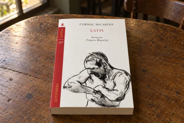 Το βιβλίο Σάτρι του Cormac McCarthy από τη Gutenberg στο κέντρο ενός ξύλινου τραπεζιού.